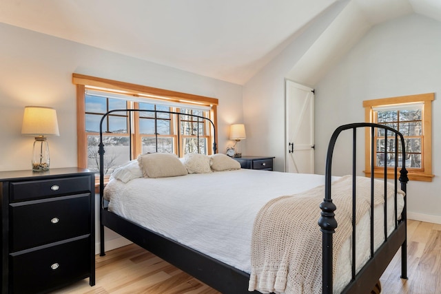 bedroom featuring light hardwood / wood-style floors and lofted ceiling