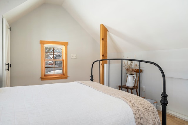 bedroom with hardwood / wood-style floors and lofted ceiling