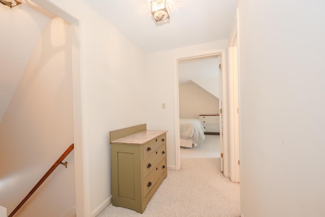 hall featuring light colored carpet and an upstairs landing