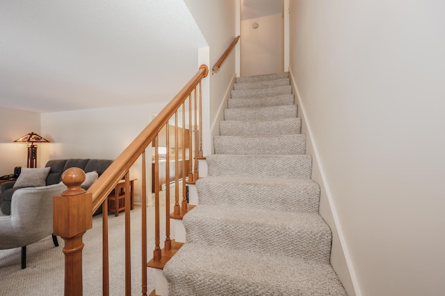 stairway featuring carpet flooring