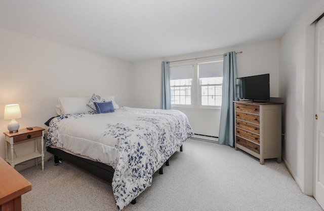 bedroom featuring a baseboard heating unit and light carpet