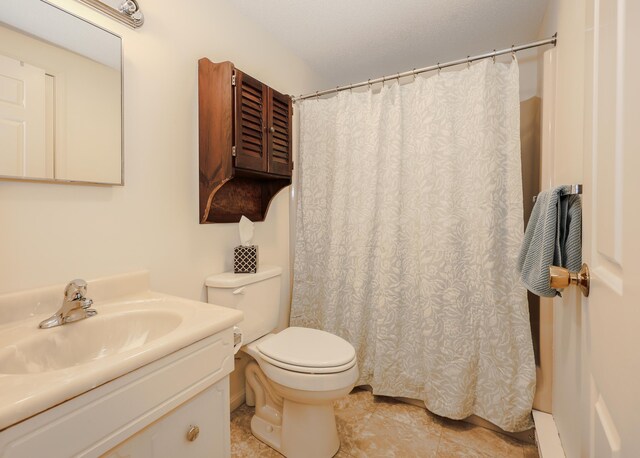 bathroom with toilet, tile patterned flooring, a textured ceiling, and vanity