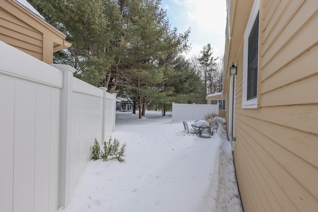 yard layered in snow featuring fence