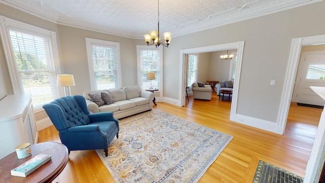 98 Fountain St, Bangor, ME 04401 - living room featuring crown molding, hardwood / wood-style floors, a textured ceiling, and an inviting chandelier