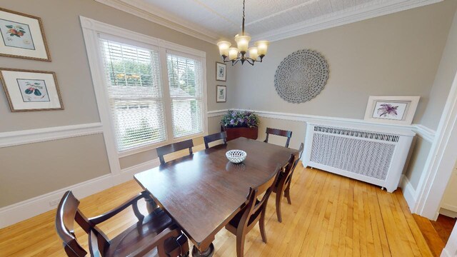 98 Fountain St, Bangor, ME 04401 - dining space with hardwood / wood-style flooring, crown molding, radiator heating unit, and a chandelier