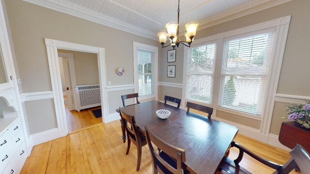 98 Fountain St, Bangor, ME 04401 - dining room featuring ornamental molding, radiator heating unit, a chandelier, and light hardwood / wood-style floors