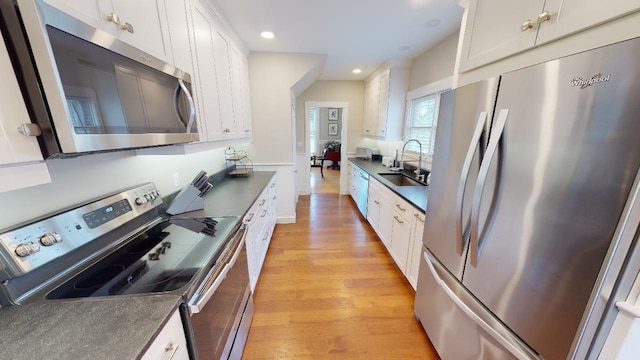 98 Fountain St, Bangor, ME 04401 - kitchen with white cabinetry, stainless steel appliances, light hardwood / wood-style floors, and sink