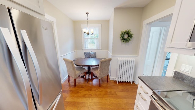 98 Fountain St, Bangor, ME 04401 - dining room with light hardwood / wood-style flooring, radiator heating unit, and a chandelier