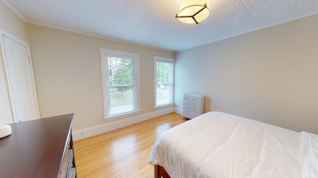 98 Fountain St, Bangor, ME 04401 - bedroom featuring radiator, a textured ceiling, and light hardwood / wood-style floors