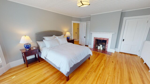 98 Fountain St, Bangor, ME 04401 - bedroom featuring hardwood / wood-style floors, a fireplace, ornamental molding, and radiator