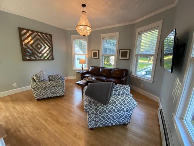98 Fountain St, Bangor, ME 04401 - living room with a baseboard radiator, a wealth of natural light, and crown molding