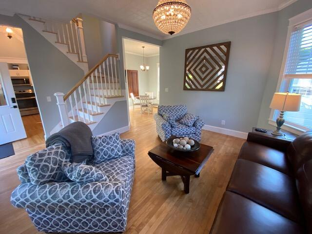 98 Fountain St, Bangor, ME 04401 - living room featuring an inviting chandelier, crown molding, and wood-type flooring