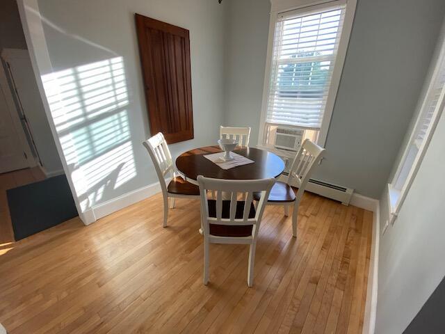 98 Fountain St, Bangor, ME 04401 - dining area featuring a baseboard radiator, cooling unit, and light hardwood / wood-style floors