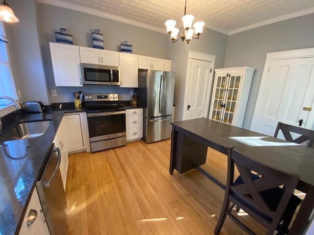 98 Fountain St, Bangor, ME 04401 - kitchen with stainless steel appliances, white cabinetry, hanging light fixtures, and sink