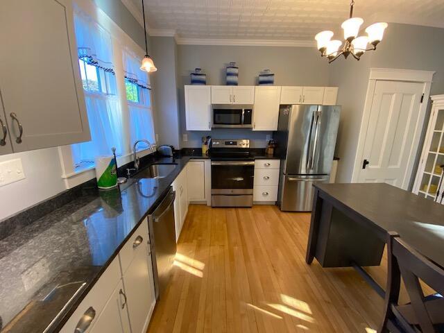 98 Fountain St, Bangor, ME 04401 - kitchen featuring decorative light fixtures, sink, white cabinets, stainless steel appliances, and crown molding