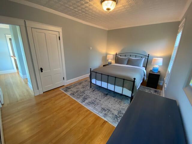 98 Fountain St, Bangor, ME 04401 - bedroom with hardwood / wood-style flooring, ornamental molding, and a closet