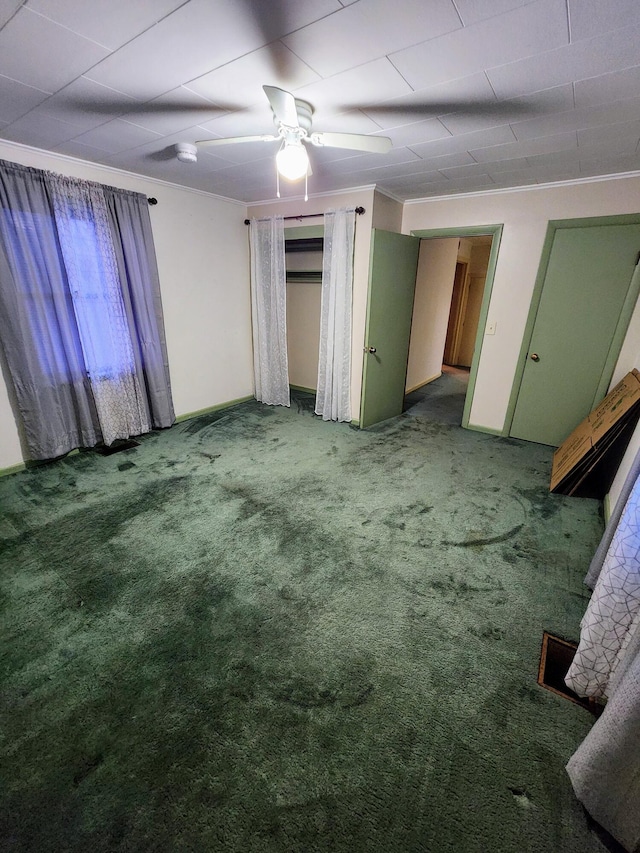 unfurnished bedroom with ceiling fan, ornamental molding, and carpet