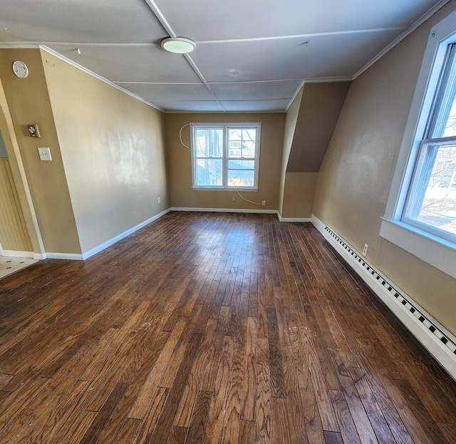 additional living space featuring a baseboard heating unit and dark hardwood / wood-style floors