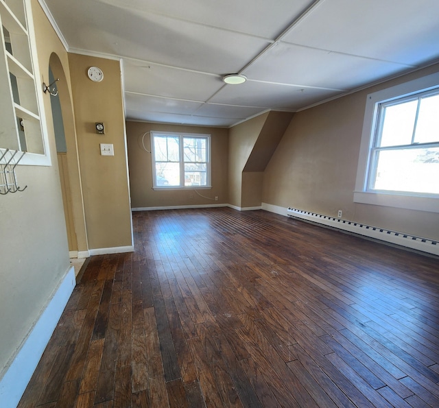 additional living space with a baseboard heating unit and dark hardwood / wood-style floors