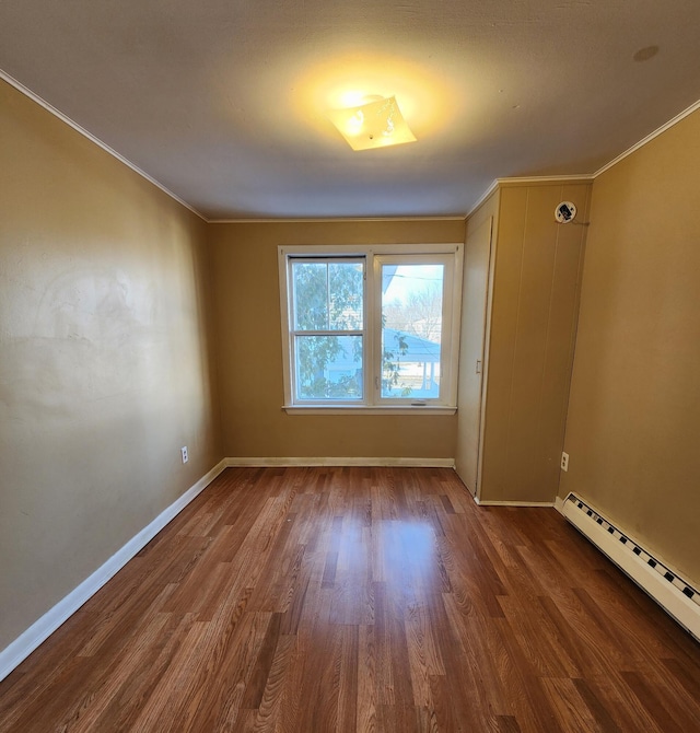 unfurnished room featuring hardwood / wood-style flooring, ornamental molding, and a baseboard heating unit