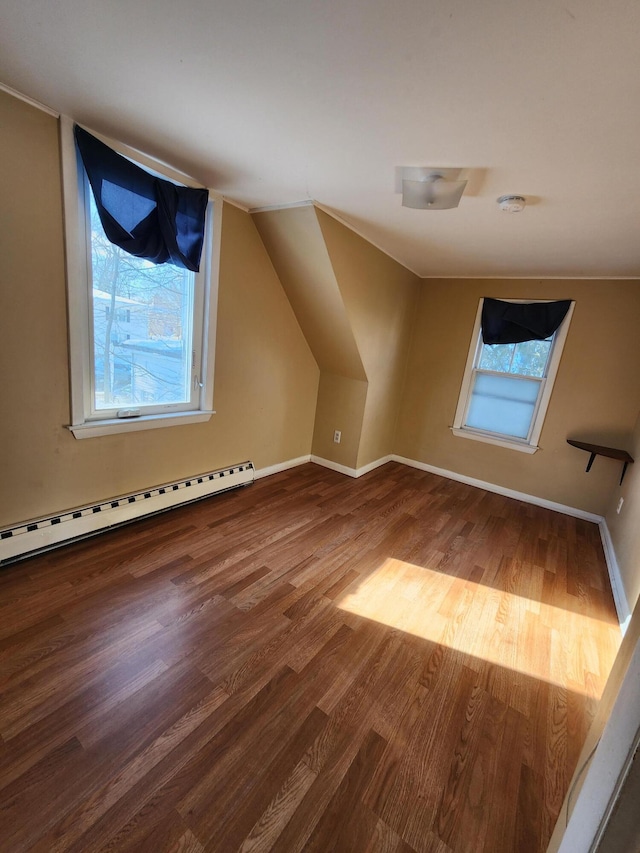 additional living space featuring hardwood / wood-style flooring, a baseboard radiator, vaulted ceiling, and a wealth of natural light