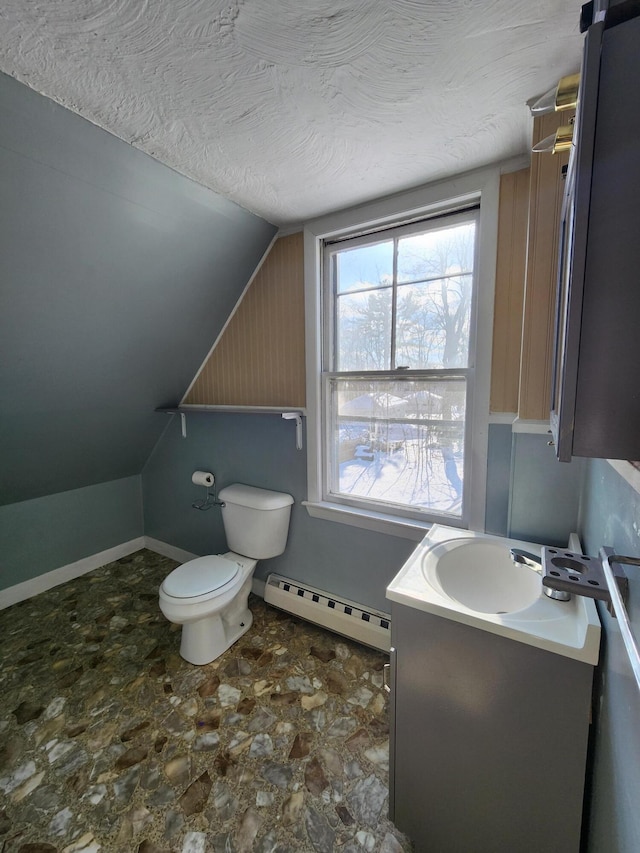 bathroom with lofted ceiling, toilet, a textured ceiling, a baseboard radiator, and vanity