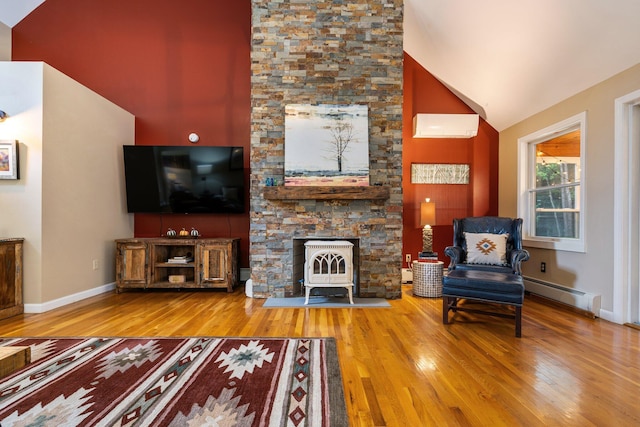 living room featuring a baseboard heating unit, high vaulted ceiling, a wall mounted air conditioner, wood-type flooring, and a wood stove