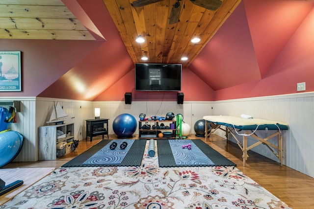 exercise room featuring wood ceiling, vaulted ceiling, and light hardwood / wood-style floors