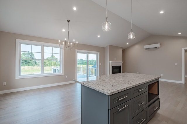 kitchen with lofted ceiling, a center island, light hardwood / wood-style flooring, a wall unit AC, and pendant lighting