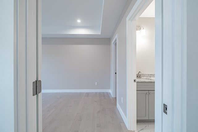 corridor featuring sink and light wood-type flooring