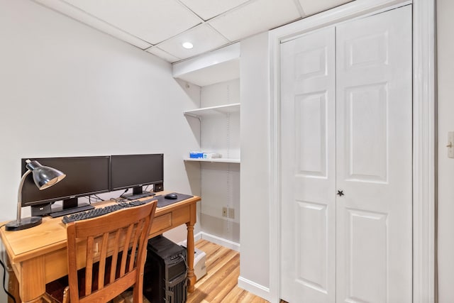 office with a drop ceiling and light wood-type flooring