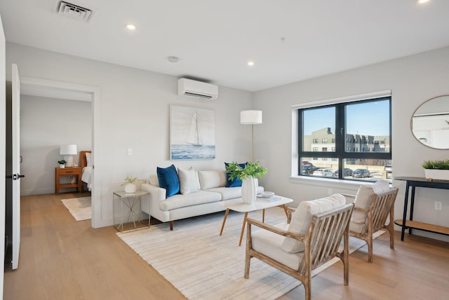 living area featuring light wood-style floors, a wall mounted air conditioner, visible vents, and recessed lighting