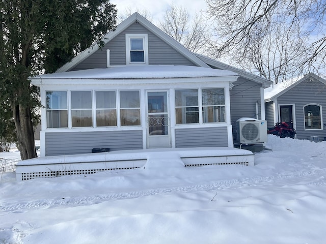 snow covered rear of property with ac unit