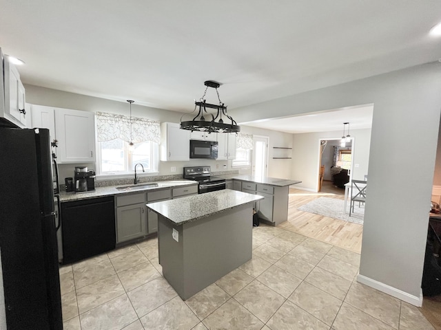 kitchen featuring pendant lighting, sink, gray cabinetry, a center island, and black appliances