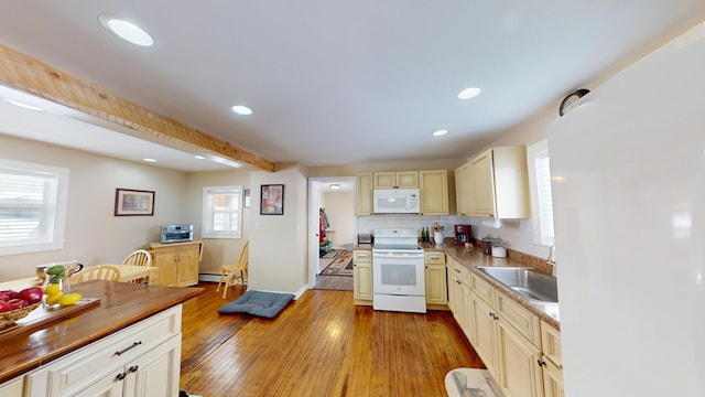 kitchen featuring sink, white appliances, cream cabinets, and light wood-type flooring