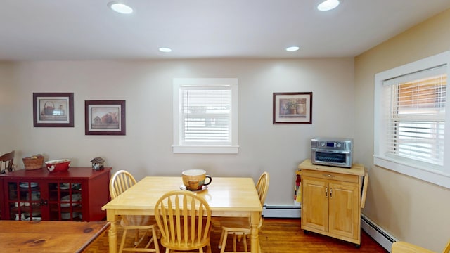 dining space featuring wood-type flooring and a baseboard heating unit