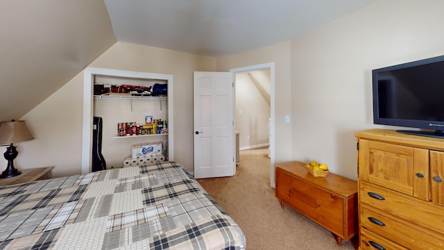 carpeted bedroom featuring lofted ceiling and a closet