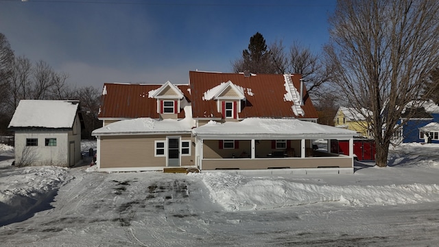 view of front of home featuring a porch and a storage shed