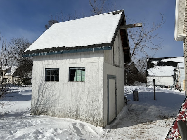 view of snow covered exterior featuring an outbuilding