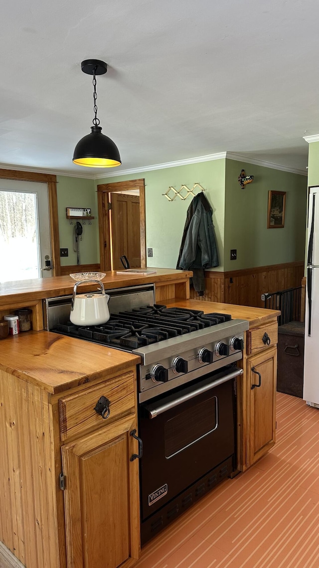 kitchen featuring butcher block countertops, crown molding, designer range, decorative light fixtures, and white fridge