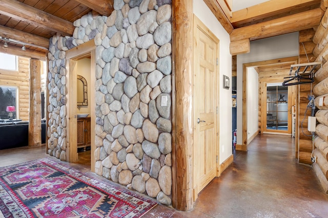 hall featuring beam ceiling, log walls, concrete floors, and wooden ceiling