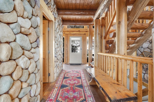 hallway featuring rustic walls, wooden ceiling, and beam ceiling