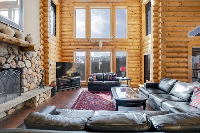 living room with hardwood / wood-style flooring, a fireplace, rustic walls, and a towering ceiling