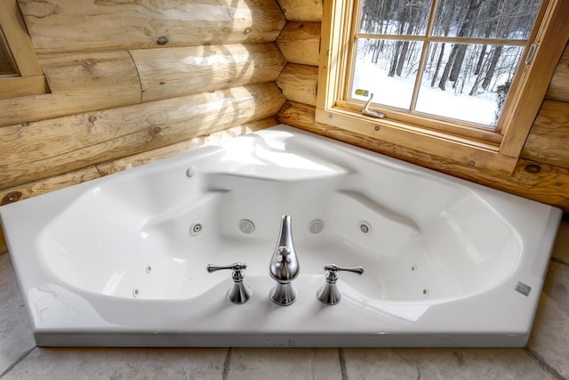 bathroom featuring a tub to relax in and rustic walls