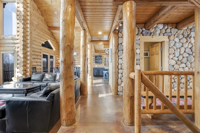 corridor featuring wood ceiling, beamed ceiling, concrete floors, and log walls