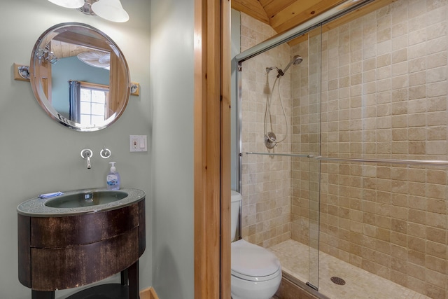 bathroom featuring toilet and a shower with shower door