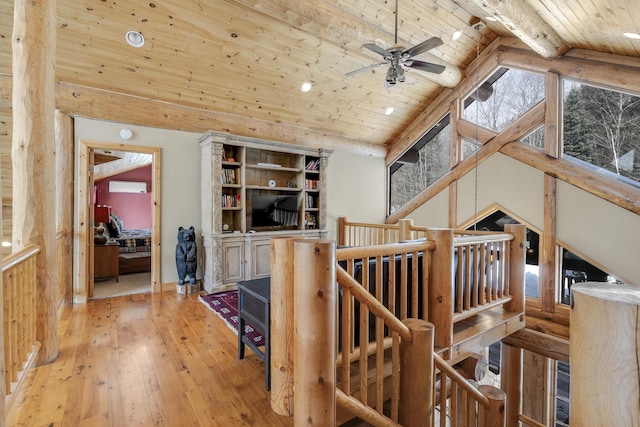 interior space featuring hardwood / wood-style floors, high vaulted ceiling, beamed ceiling, a wall mounted AC, and wooden ceiling