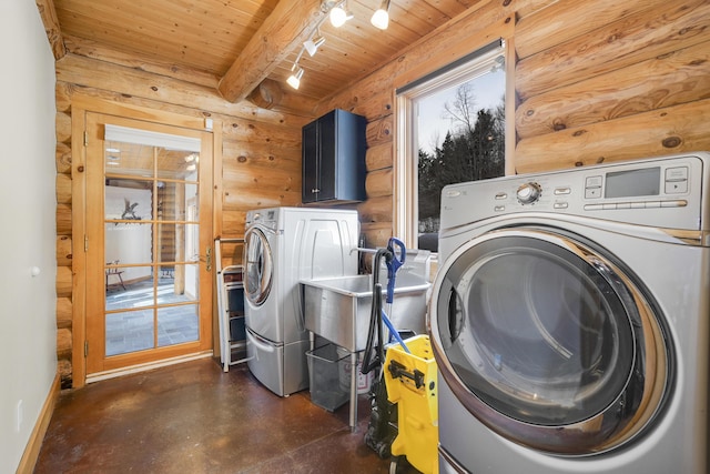 washroom featuring rail lighting, rustic walls, washing machine and dryer, and wooden ceiling