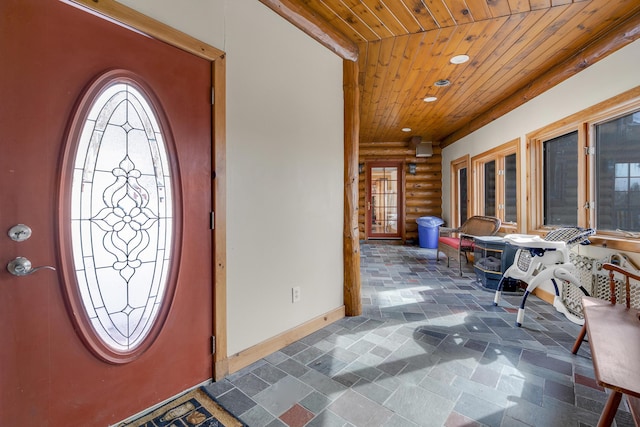 entrance foyer featuring wood ceiling and rustic walls