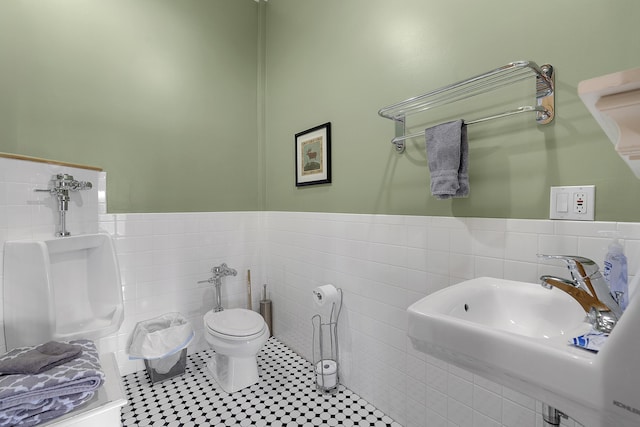 bathroom with toilet, tile patterned flooring, sink, and tile walls